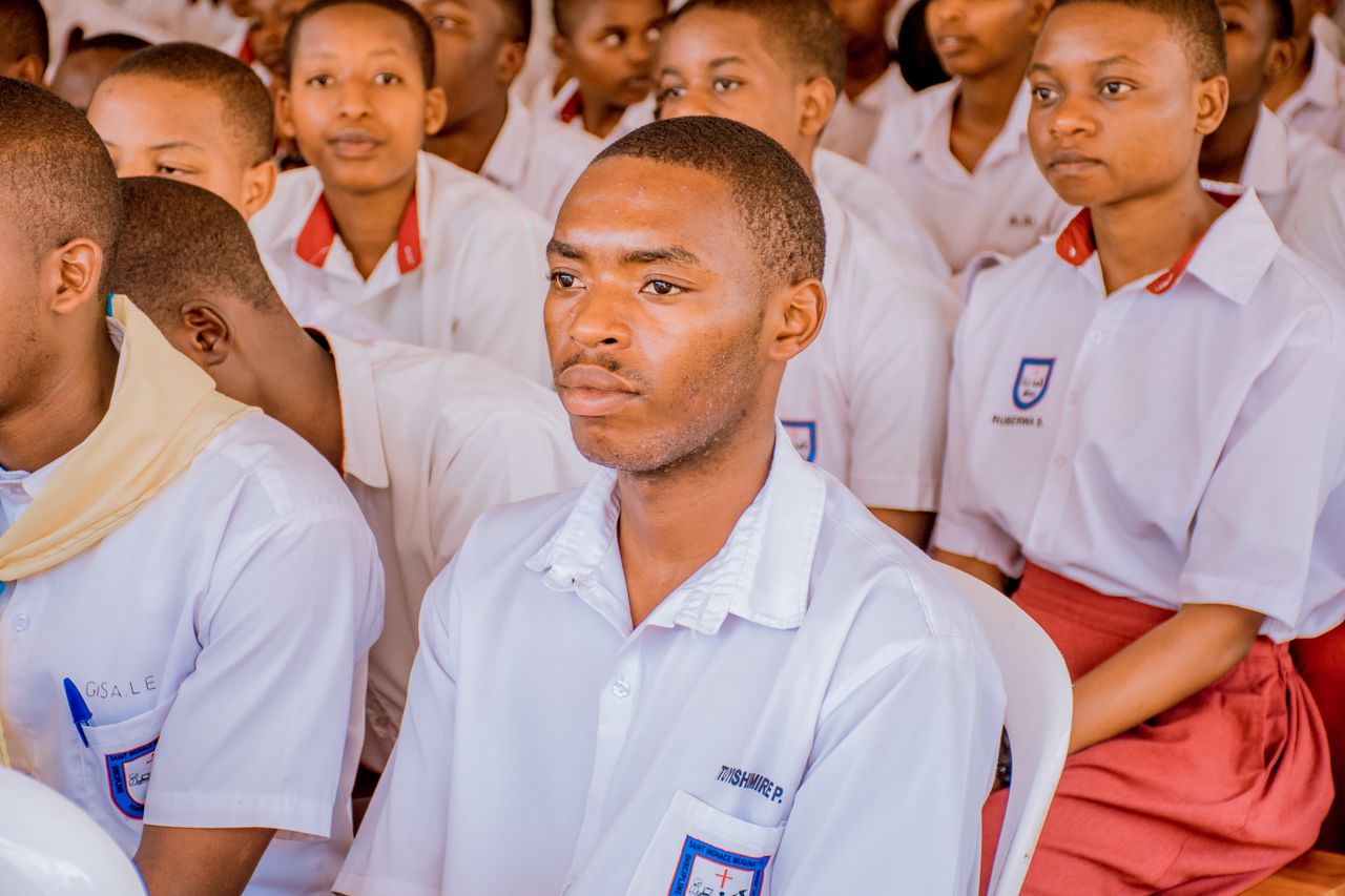 A group of students attending a lecture wearing school uniforms, focused and attentive.